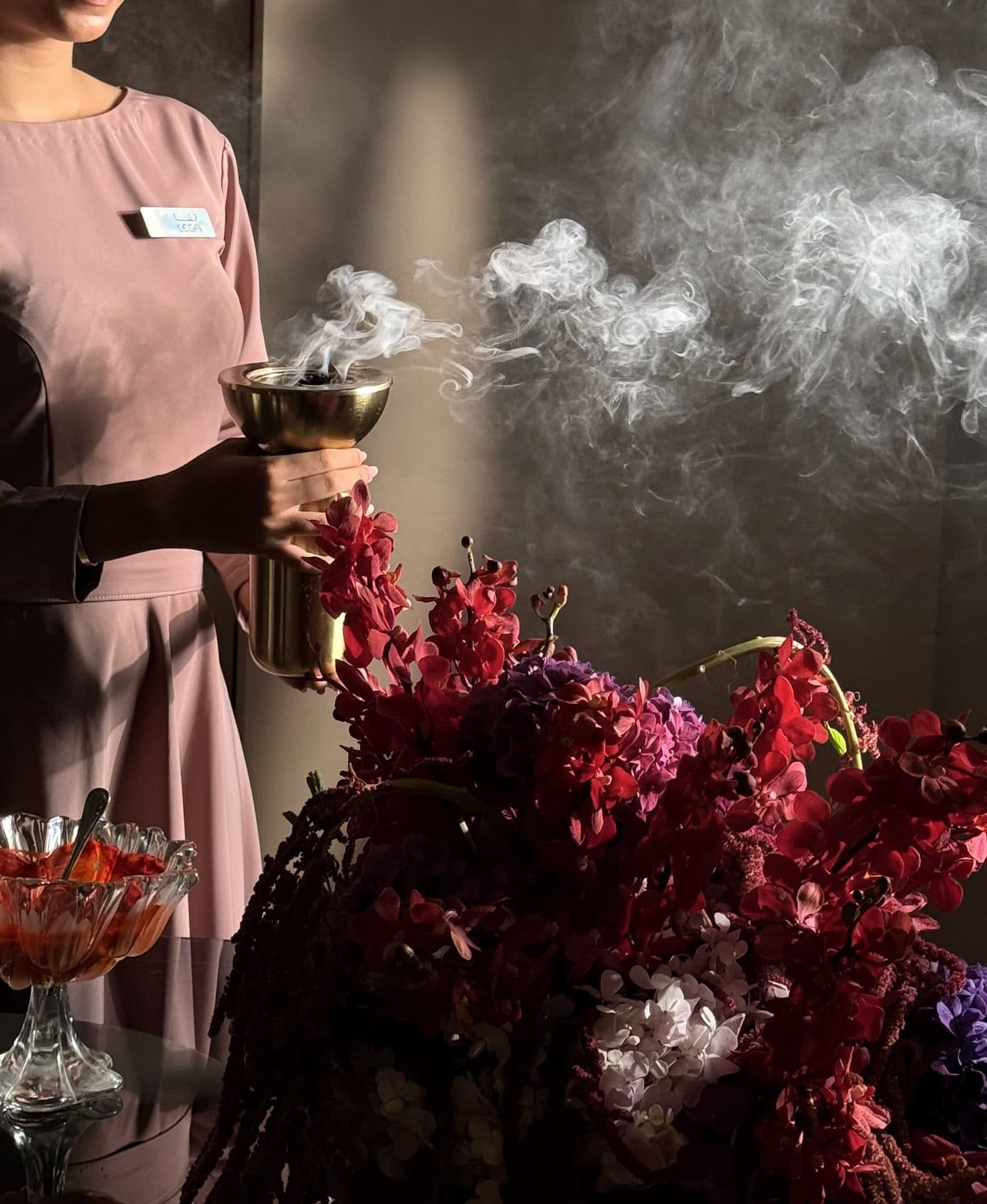 Bakhoor smoke rising from a mabkhara on the perfume table